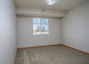 Thumbnail 25 of 33 - A room with a carpeted floor and a window.