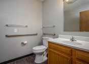 Thumbnail 27 of 33 - A white toilet sits next to a white sink in a bathroom.