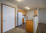 Thumbnail 9 of 33 - A kitchen with a white refrigerator and wooden cabinets.