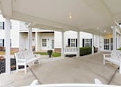 Thumbnail 9 of 66 - A white covered patio with benches and a table.