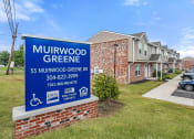 Thumbnail 5 of 37 - a sign in front of a building with apartments in the background