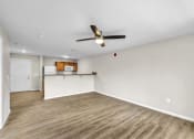 Thumbnail 6 of 51 - an empty living room with a ceiling fan and a kitchen