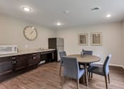 Thumbnail 34 of 45 - a dining room with a table and chairs and a refrigerator and microwave