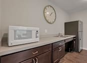 Thumbnail 36 of 45 - a kitchen with a microwave and a sink and a clock