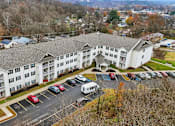 Thumbnail 62 of 66 - A large white building with a parking lot in front of it.