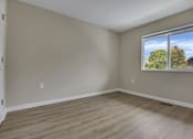 Thumbnail 3 of 9 - A room with a window showing trees and sky outside.