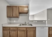 Thumbnail 10 of 18 - A kitchen with wooden cabinets and a white dishwasher.