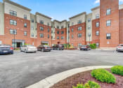 Thumbnail 3 of 25 - a large brick building with a parking lot in front of it