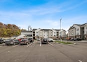 Thumbnail 45 of 84 - a parking lot with cars in front of an apartment complex