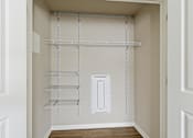 Thumbnail 31 of 53 - A white pantry with shelves and a light switch.