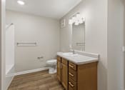 Thumbnail 27 of 53 - A bathroom with a toilet, sink, and mirror.