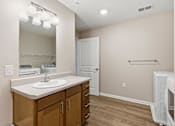 Thumbnail 24 of 53 - A bathroom with a sink, mirror, and wooden cabinets.