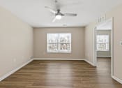 Thumbnail 28 of 52 - A room with a ceiling fan and wooden flooring.
