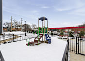 Thumbnail 25 of 53 - A playground with a slide and swings covered in snow.