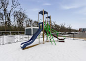 Thumbnail 48 of 53 - A playground with a blue and green slide in the snow.