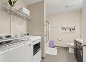 Thumbnail 14 of 15 - A laundry room with a washer and dryer.