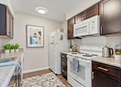 Thumbnail 13 of 15 - A kitchen with a white stove top oven and a white refrigerator.