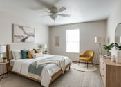 Thumbnail 27 of 29 - A bedroom with a bed, chair, and a ceiling fan.