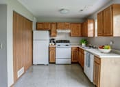 Thumbnail 28 of 29 - A kitchen with wooden cabinets and a white refrigerator.