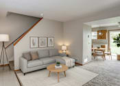 Thumbnail 26 of 29 - A living room with a grey couch, a wooden coffee table, and a lamp on a tripod.