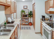 Thumbnail 17 of 20 - A kitchen with a white oven and a white sink.