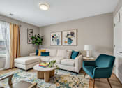 Thumbnail 52 of 52 - A living room with a white couch, a blue chair, and a rug.