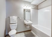 Thumbnail 30 of 30 - A white toilet sits next to a sink in a small bathroom.