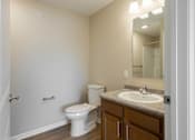 Thumbnail 5 of 58 - A bathroom with a toilet, sink, and mirror.