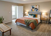 Thumbnail 28 of 30 - A bedroom with a bed, nightstands, and a mirror.
