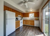 Thumbnail 8 of 9 - A kitchen with wooden cabinets and a white refrigerator.