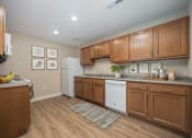 Thumbnail 45 of 48 - A kitchen with wooden cabinets and a white fridge.