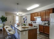 Thumbnail 26 of 29 - A modern kitchen with white appliances and wooden cabinets.
