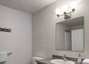 Thumbnail 29 of 29 - A white toilet sits next to a sink in a bathroom.
