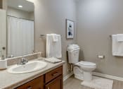 Thumbnail 26 of 28 - A bathroom with a toilet, sink, and towel rack.