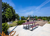 Thumbnail 38 of 38 - A playground with a slide and picnic table.