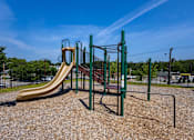 Thumbnail 27 of 38 - A playground with a yellow slide and green monkey bars.