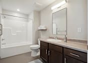 Thumbnail 38 of 38 - A white toilet sits in a bathroom next to a sink and a bathtub.