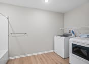 Thumbnail 15 of 19 - an empty laundry room with two washes and a dryer in it
