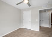 Thumbnail 14 of 19 - a bedroom with a ceiling fan and a door to a closet
