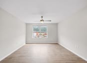 Thumbnail 18 of 19 - an empty living room with a ceiling fan and a window