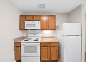 Thumbnail 5 of 19 - a kitchen with white appliances and wooden cabinets