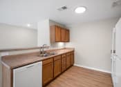 Thumbnail 10 of 19 - a kitchen with wooden cabinets and a sink and a refrigerator