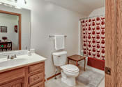 Thumbnail 16 of 17 - A bathroom with a toilet, sink, and shower curtain.