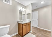 Thumbnail 53 of 54 - A bathroom with a white toilet and a wooden vanity.