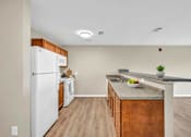 Thumbnail 54 of 54 - A kitchen with a white refrigerator, wooden cabinets, and a marble countertop.