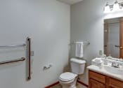 Thumbnail 23 of 24 - A white toilet sits in a bathroom next to a white sink.