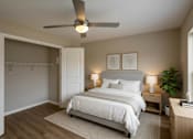 Thumbnail 23 of 24 - A bedroom with a bed, nightstand, and a ceiling fan.