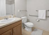 Thumbnail 47 of 48 - A white toilet sits next to a sink in a bathroom.