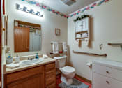 Thumbnail 34 of 36 - A bathroom with a toilet, sink, and a mirror.