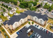 Thumbnail 36 of 48 - a large apartment complex with a parking lot and grassy area
